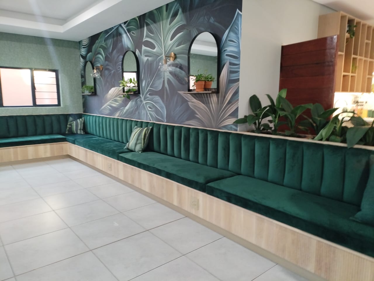 Custom green channel-tufted banquette seating installed in a café